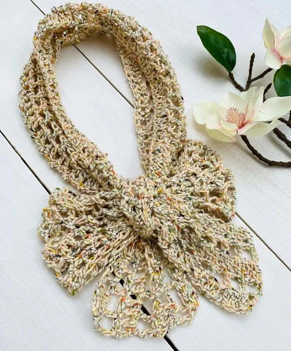 A flat lay image of a lacy crochet hair scarf.