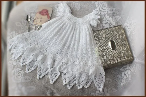 A white, crochet lace christening dress.