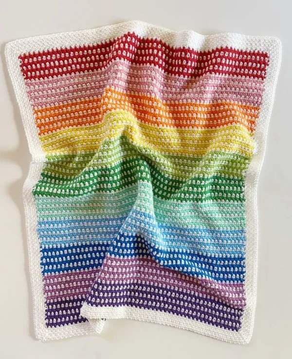 A crochet rainbow moss stitch baby blanket.
