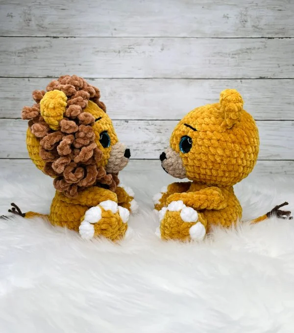 A crochet lioness and lion sitting together.