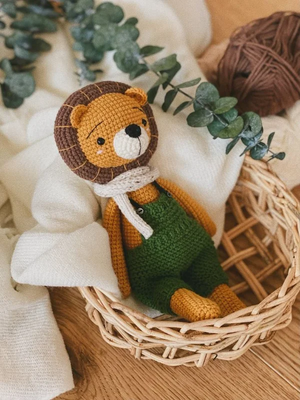 A crochet lion with green overalls.