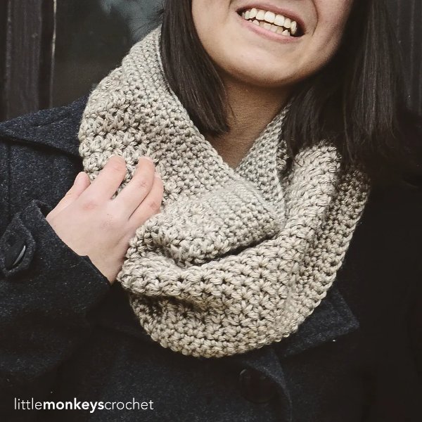 A woman werring a beige, textured crochet cowl.