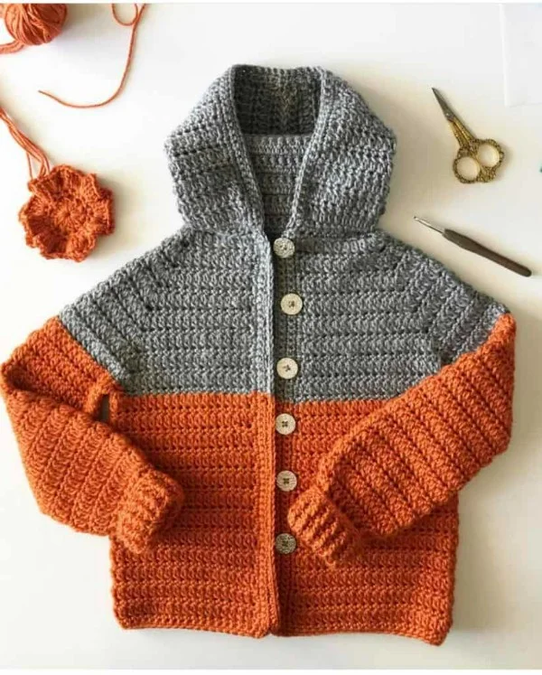 A flat lay image of a colour-blocked crochet childrens hoodie.