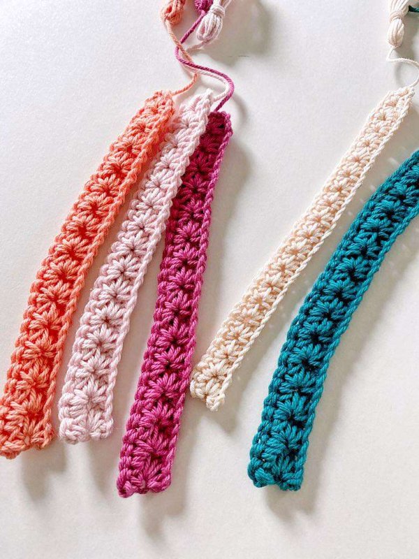 Five different coloured crochete bookmarks.