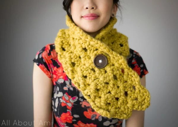 A woman wearing a chunky crochet button cowl.