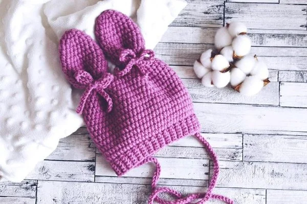 A pink crochet hat with ears.