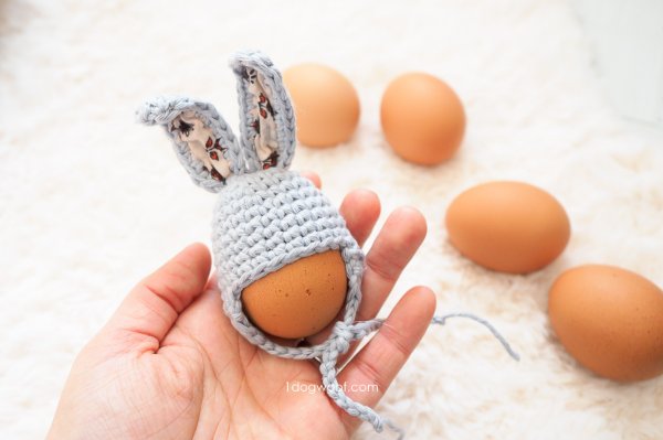 A bunny-themed earflap hat egg cozy.