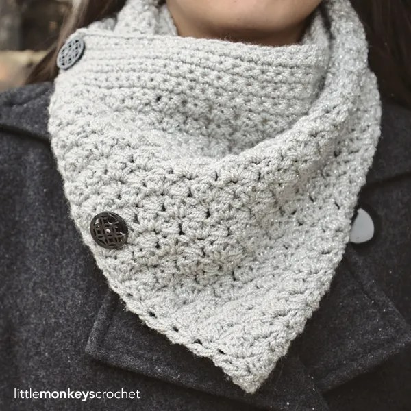 A close up of a buttoned crochet cowl.