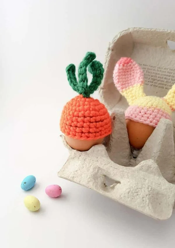 A hardboiled egg with a an orange carrot-top cozy.