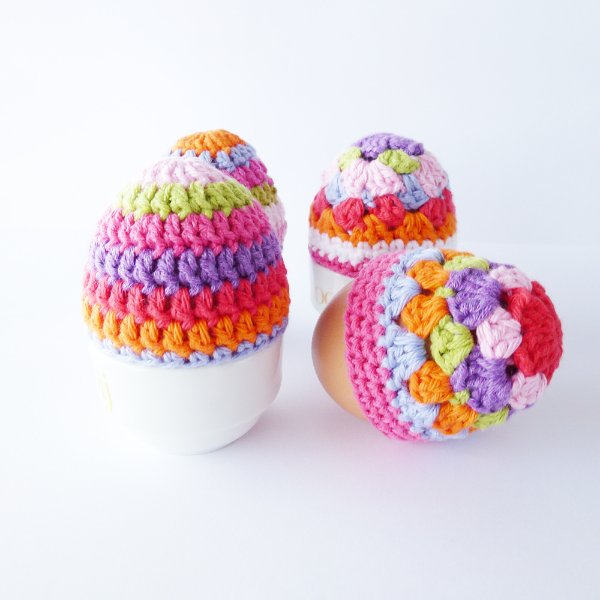 Brightly coloured crochet egg cozies featuring granny stitch and stripes.