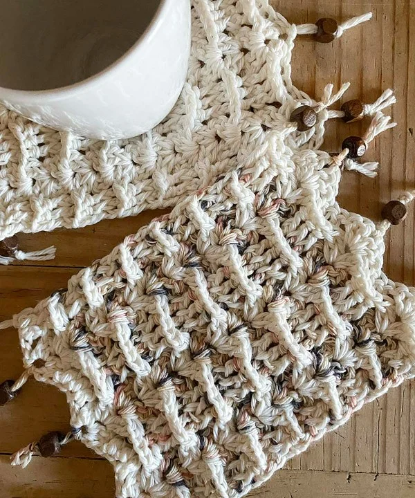 Two crochet mug rugs with beaded tassels.
