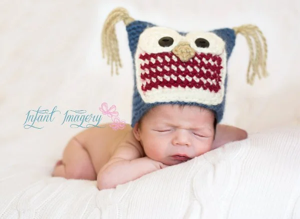 A newborn baby in a crochet owl hat.