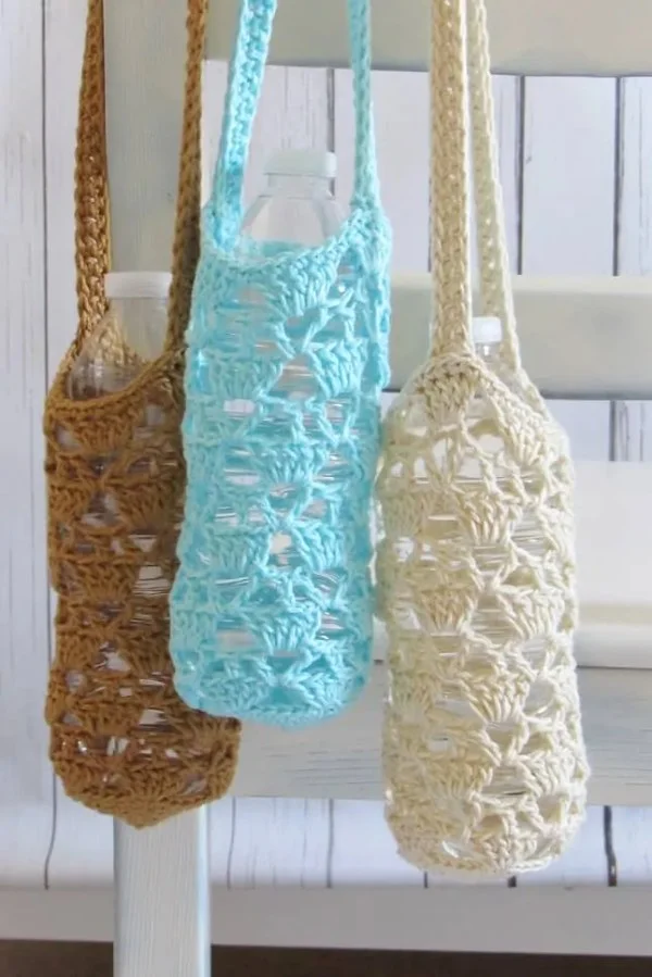 Three different coloured crochet bottle holders.