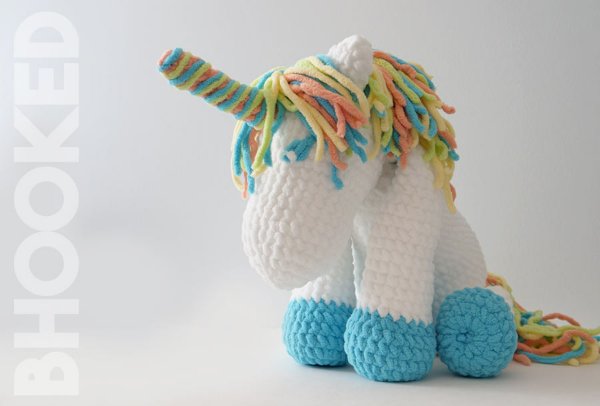 A crochet unicorn with blue feet.