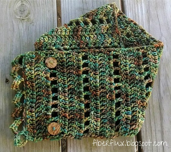 A crochet button cowl made in variegated green and brown yarn.