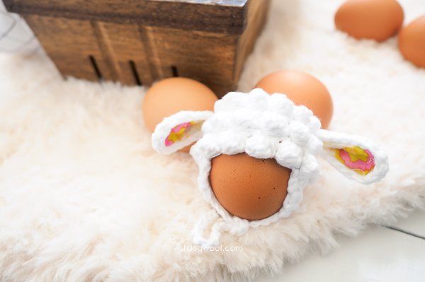 A lamb-themed crochet egg hat.