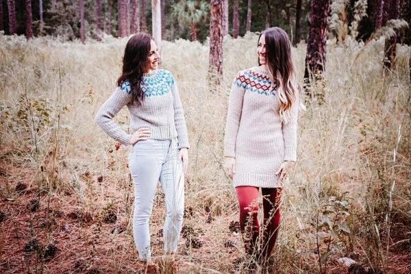 Two women in a field, one wearing a crochet sweater dress featuring Fair Isle colourwork.