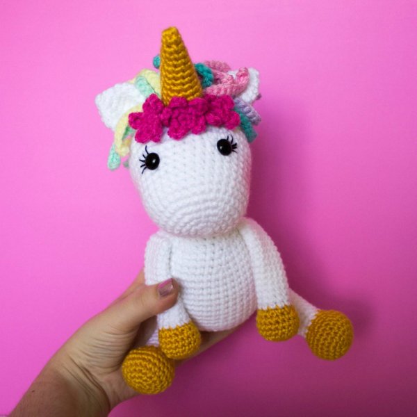 An amigurumi unicorn with a crochet flower crown.