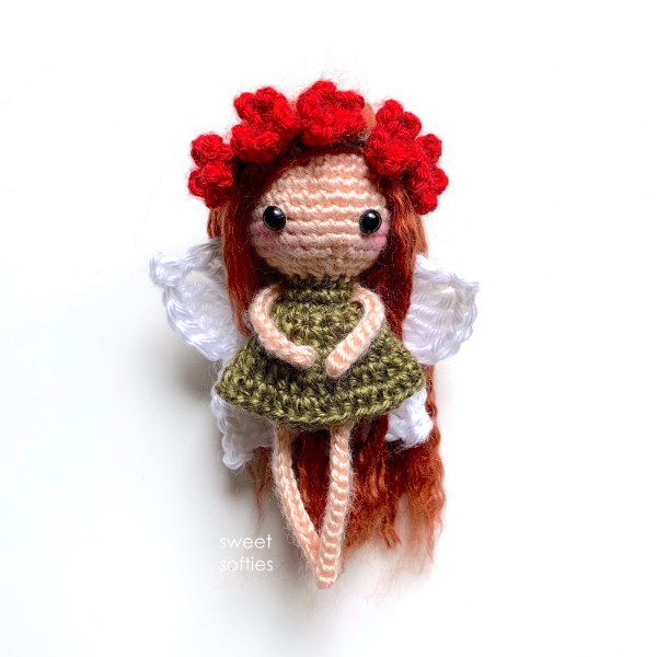 A crochet fairy with a flower headband.