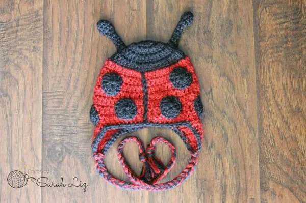 A ladybug-themed crochet earflap hat.