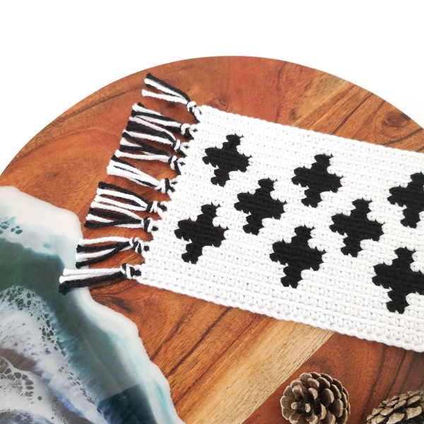 A graphic, black and white crochet mug rug.