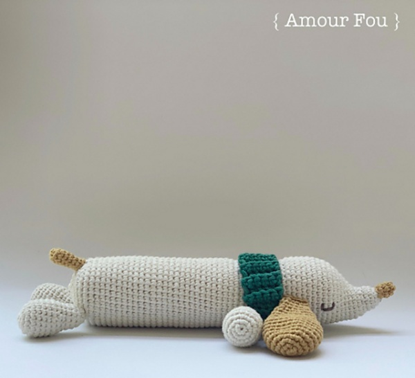 An amigurumi crochet sausage dog with a green collar.