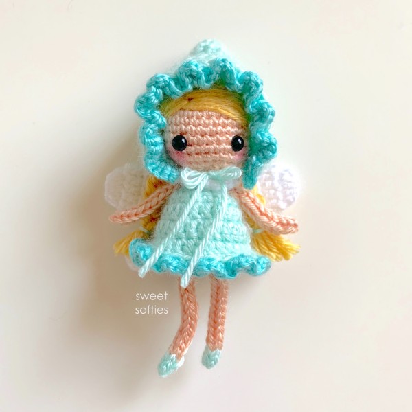 A crochet fairy with a blue bonnet.