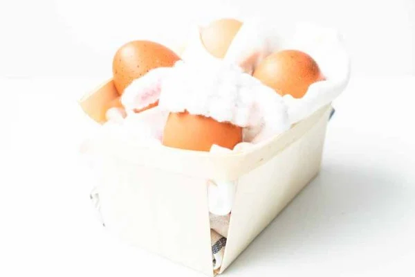 A basket of hard-boiled eggs with sheep-themed crochet egg cozies.