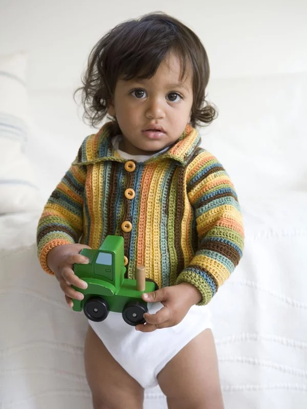 A toddler wearing a striped crochet cardigan with a collar.