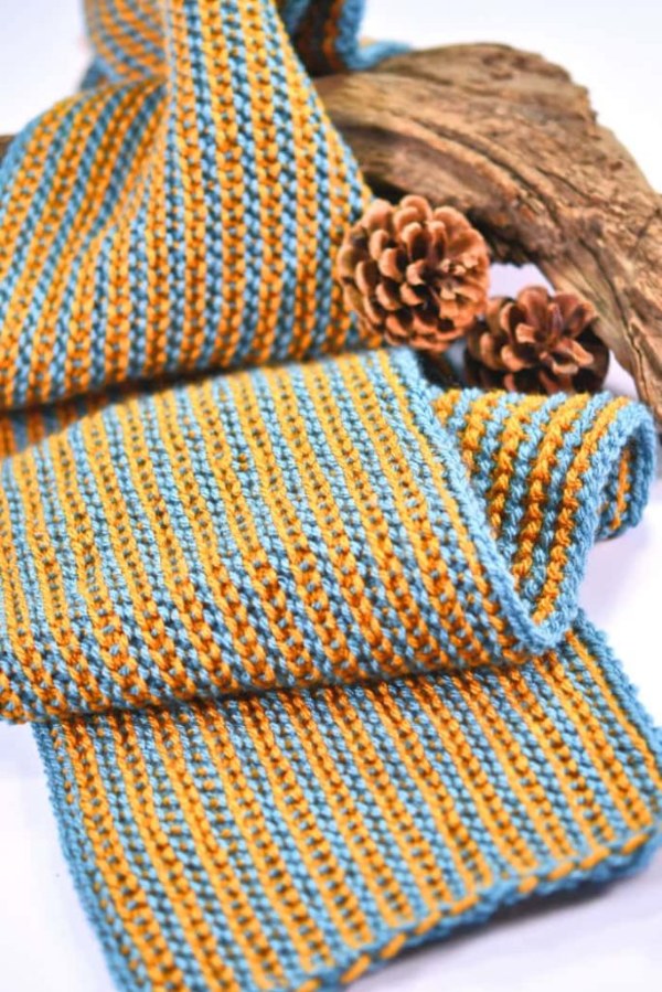 A Tunisian crochet scarf featuring blue and yellow skinny stripes.