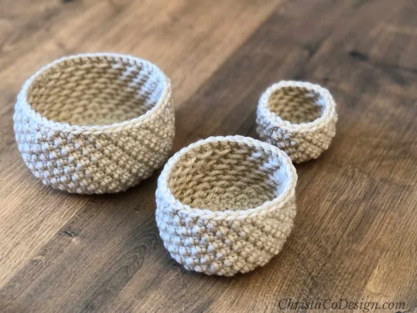 Three small, textured crochet nesting baskets.