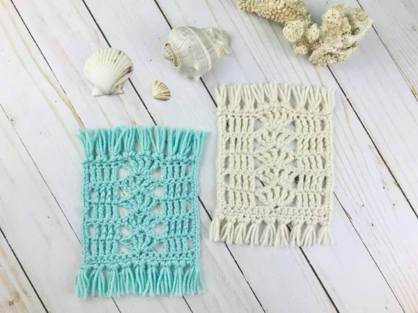 Blue and cream crochet mug rugs featuring the shell stitch.