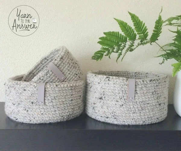 Three crochet nesting baskets crocheted in tweedy yarn.