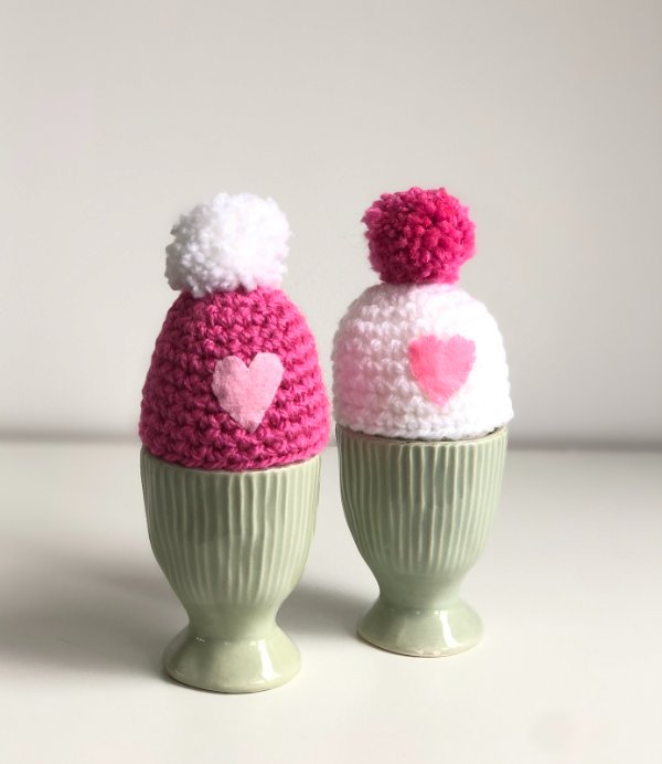 Twp oink crochet egg cozies with applique hearts.