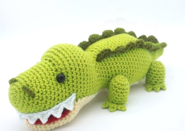 A crochet alligator with spiky green scales.