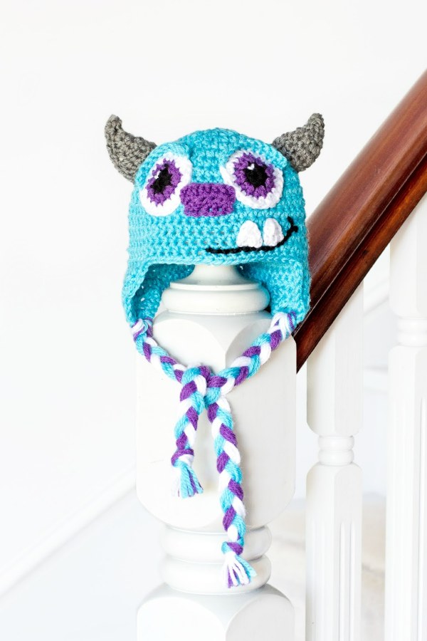 A monster-themed crochet baby earflap hat.