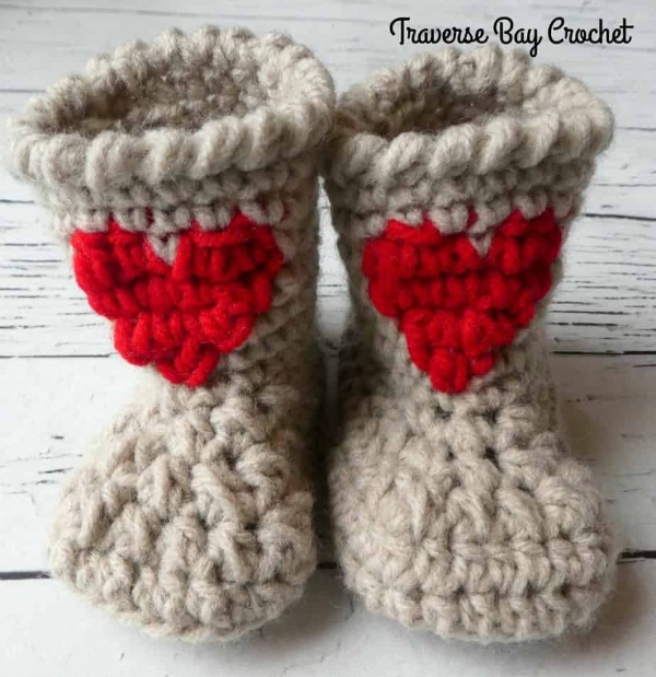 Crochet booties with heart appliques.