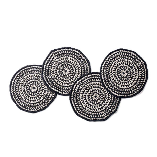 Four round crochet placemats featuring black and white colourwork.