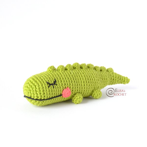 A long crochet crocodile with rosy cheeks.