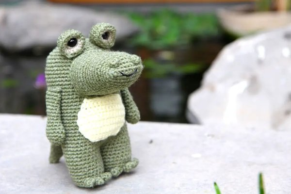 A standing crochet alligator with buggy eyes.