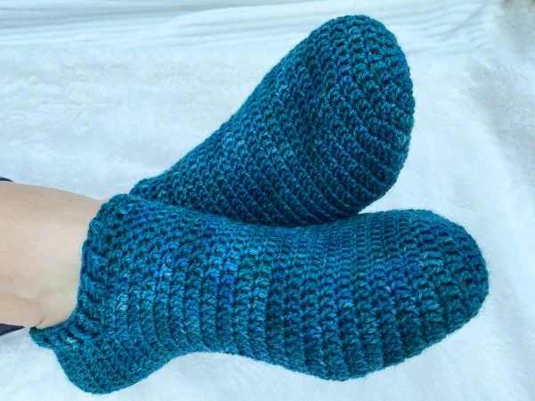 A closeup of feet in blue crochet socks.