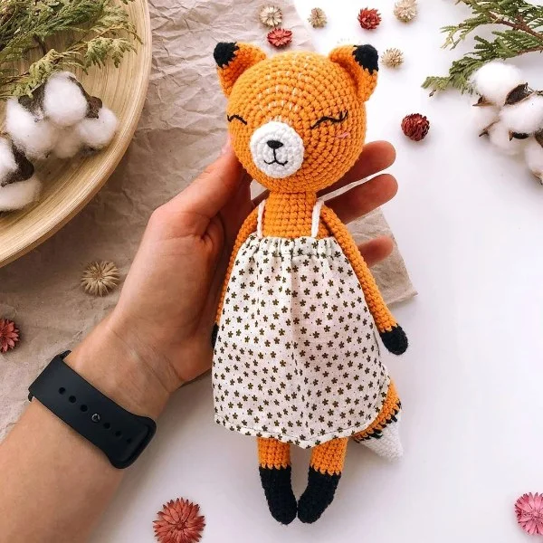 A sweet crochet fox doll with a cloth dress.