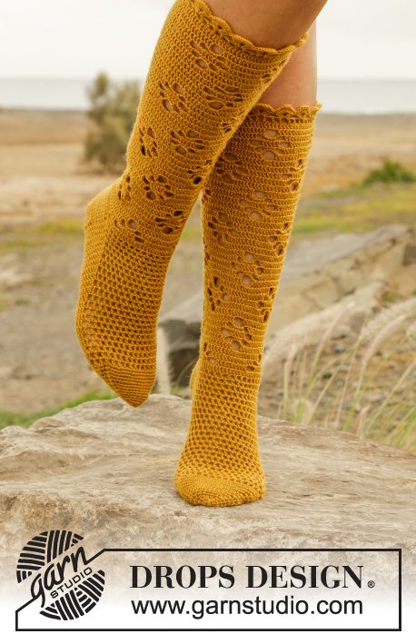 Closeup of a person wearing yellow, lacy crochet socks.