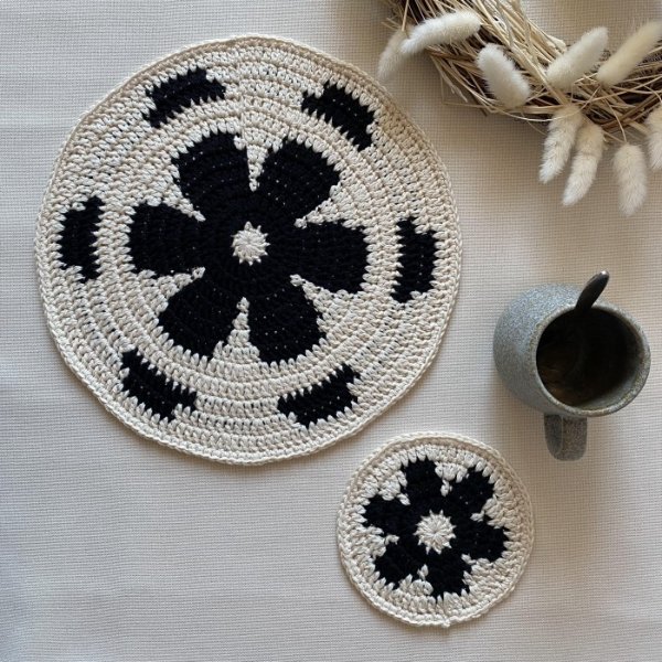 Black and white crochet placemats with a retro floral motif.