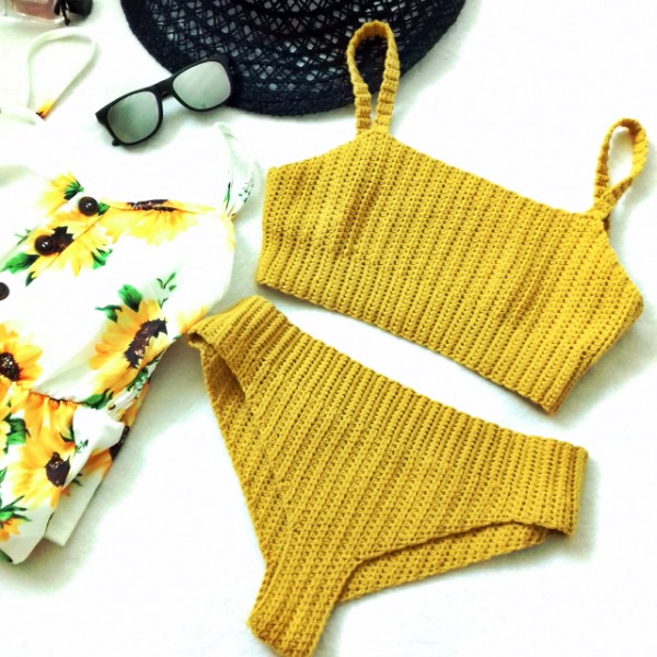 A flat lay image of a yellow crochet bkini with a ribbed stitch design and cropped top.