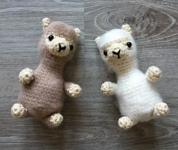 Two mini crochet alpacas with fluffy fur.
