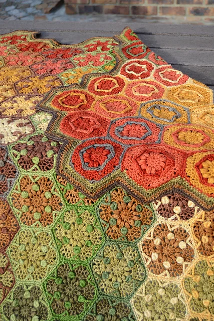 A crochet blanket with autumn-toned hexagons.