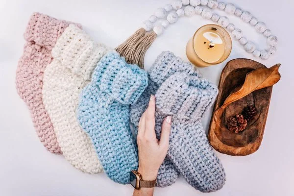 Multiple pairs of chunky crochet slipper socks in different colours.