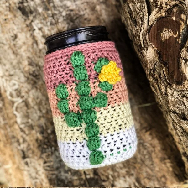 A crochet mason jar cover with a cactus motif.