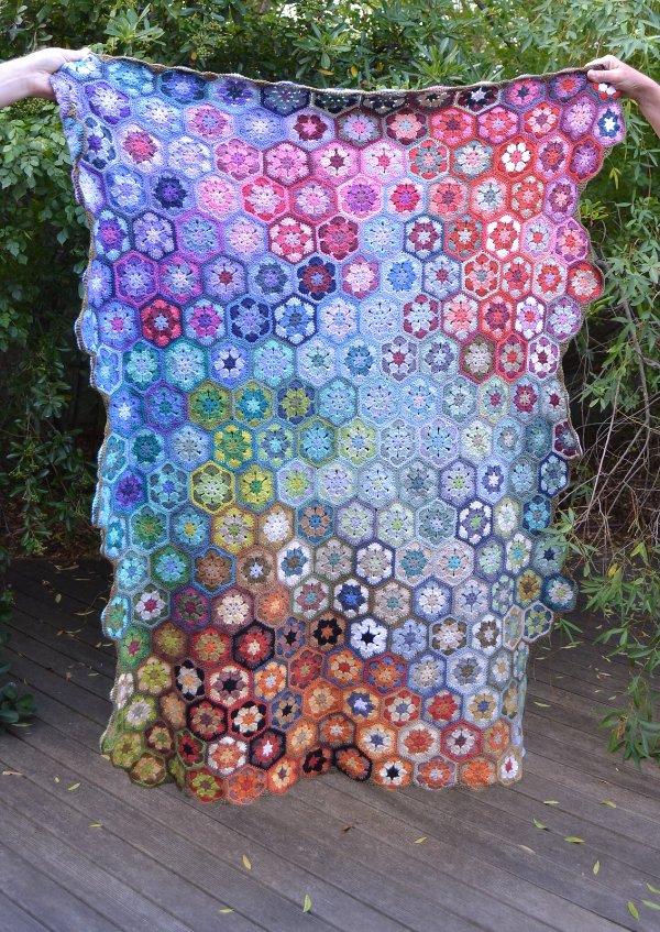 A multi-coloured crochet blanket made from mini hexagon motifs.